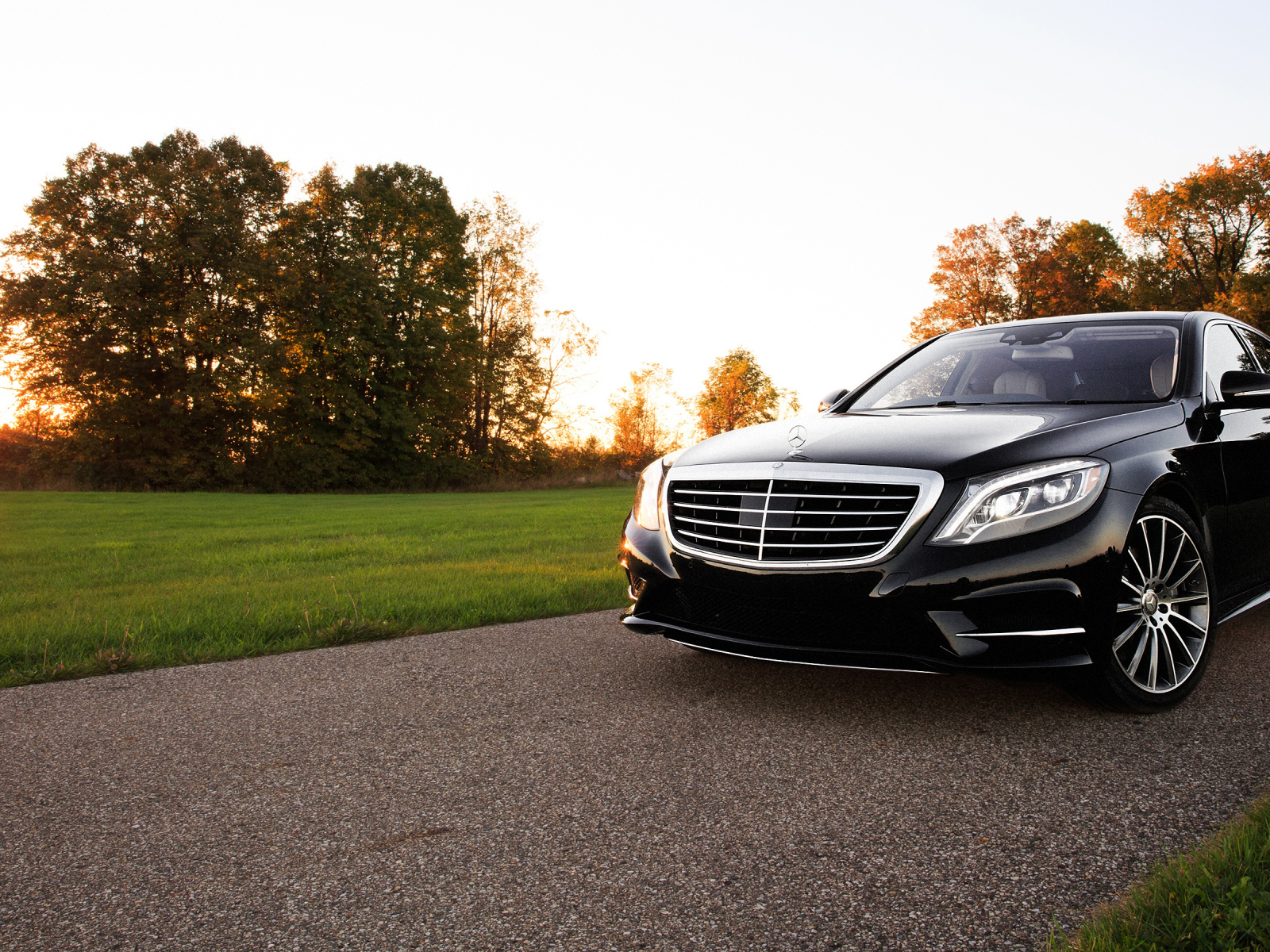 Черный автомобиль Mercedes-Benz W222 S-Class на фоне солнца