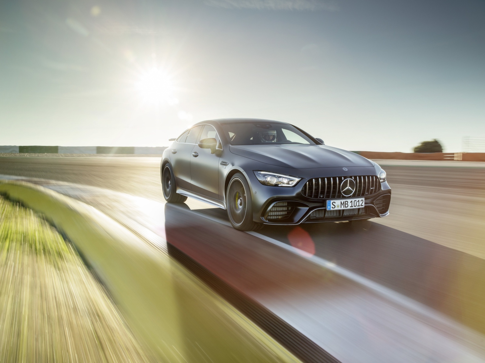 Серебристый автомобиль Mercedes-AMG GT4, 2018 года на скорости 