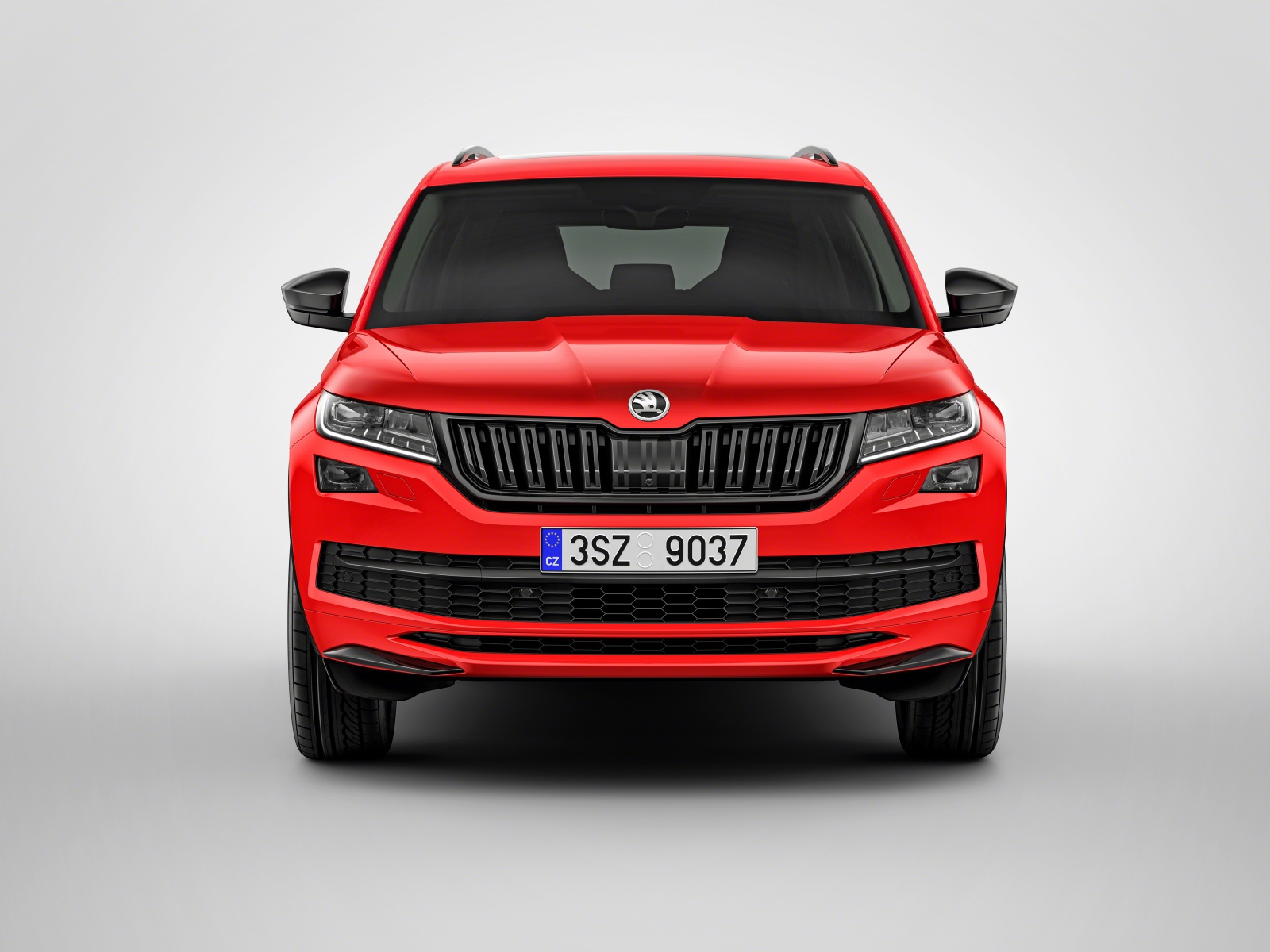 Красный автомобиль Skoda Kodiaq на сером фоне