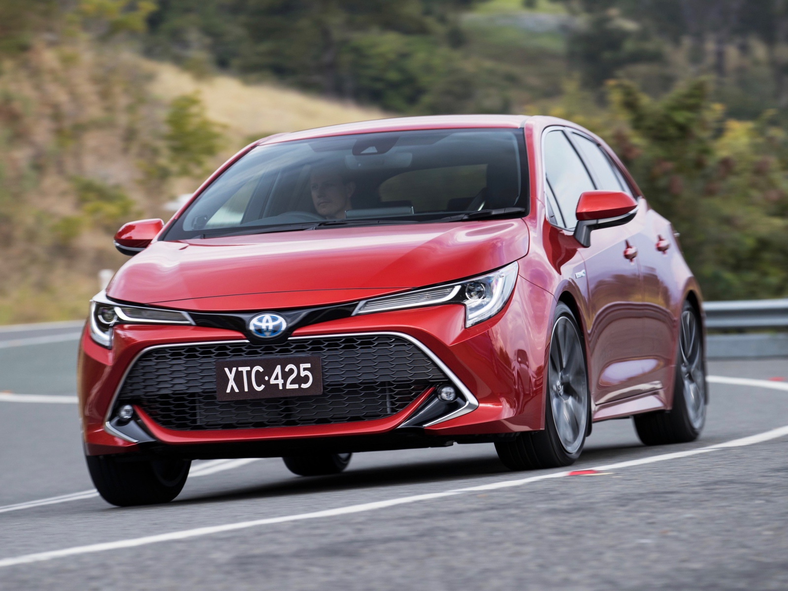 Красный автомобиль Toyota Corolla 2019 года на трассе