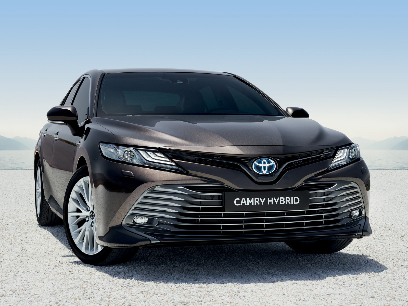 Автомобиль Toyota Camry Hybrid 2019 года стоит на песке