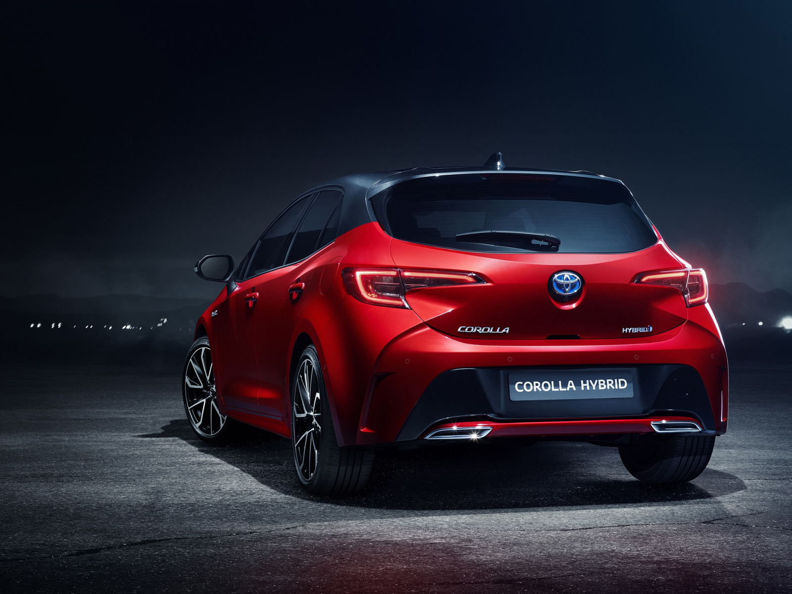 Красный автомобиль Toyota Corolla Hybrid, 2018 года вид сзади