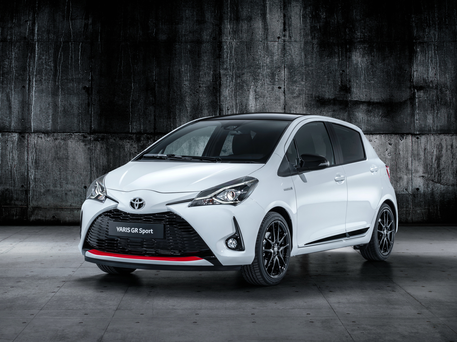 Белый автомобиль Toyota Yaris на сером фоне 