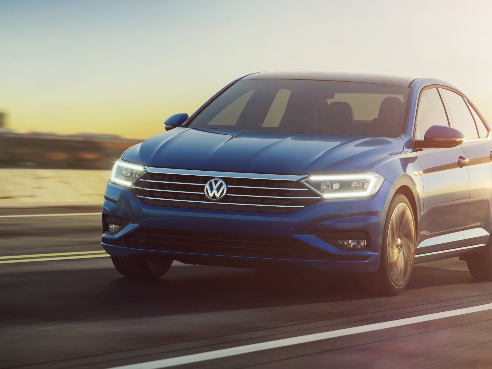 Синий автомобиль Volkswagen Jetta, 2019 на трассе