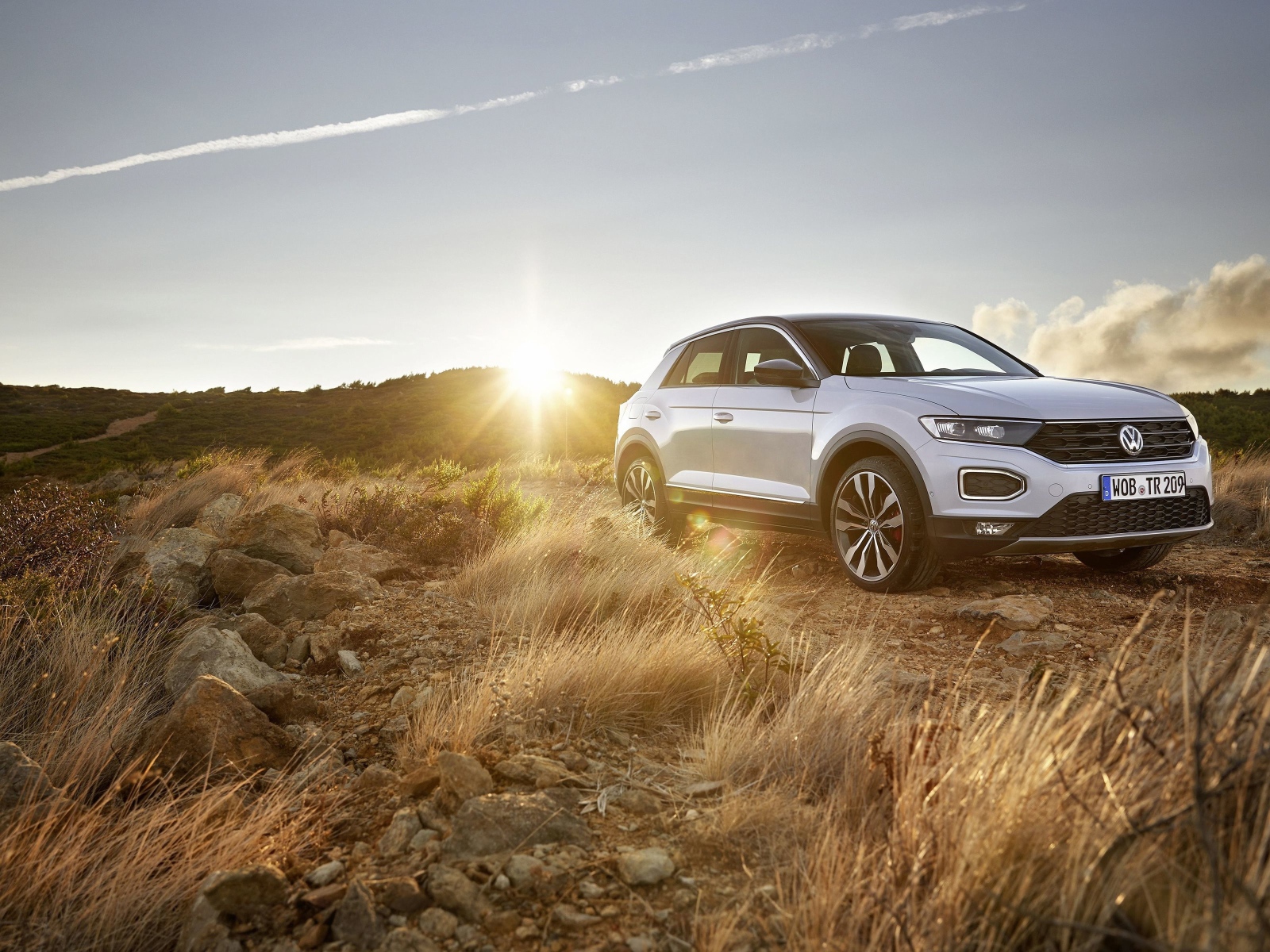 Серебристый внедорожник Volkswagen T-Roc, 2018 года на фоне солнца