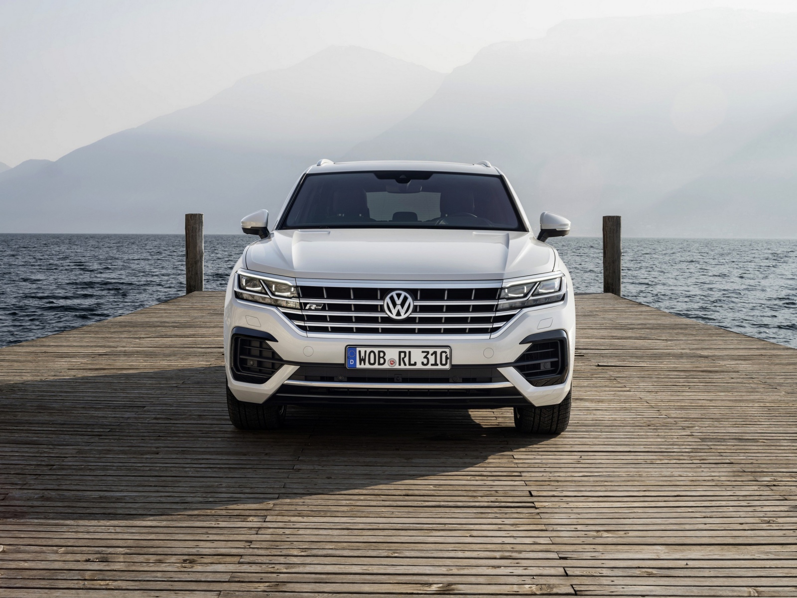 Белый автомобиль Volkswagen Touareg, 2018 года на мосту
