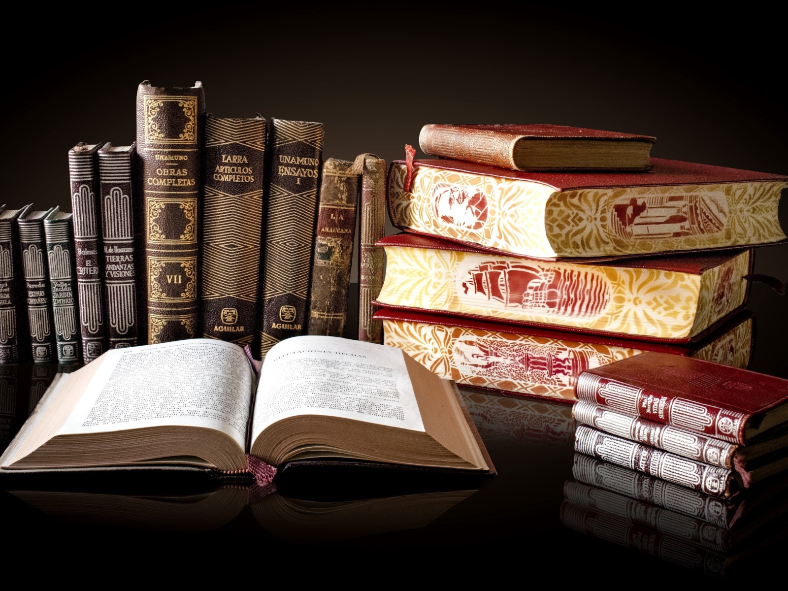 Красивые книги отражаются в зеркальной поверхности стола