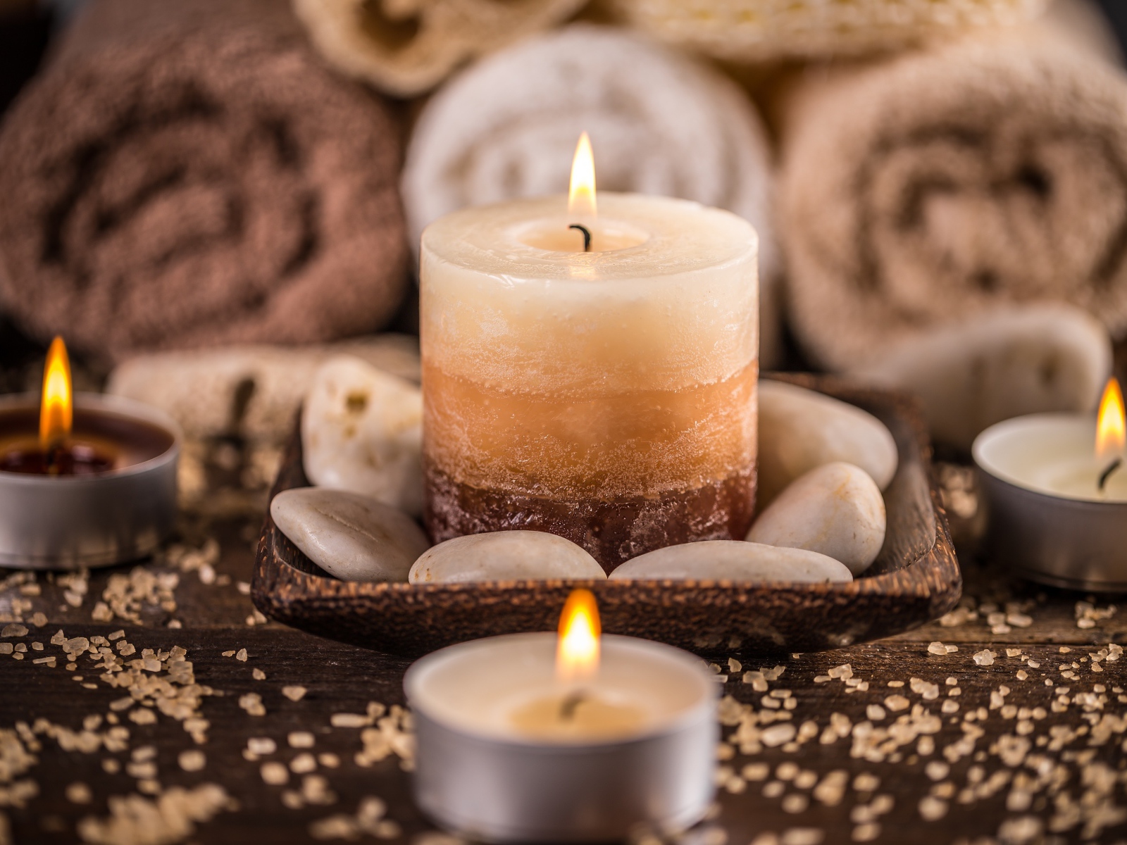 Зажженная свеча с камнями для SPA процедур