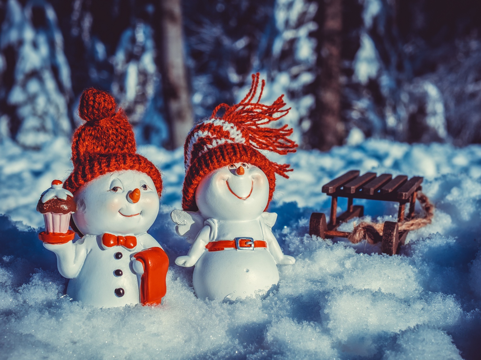 Две статуэтки снеговиков на снегу