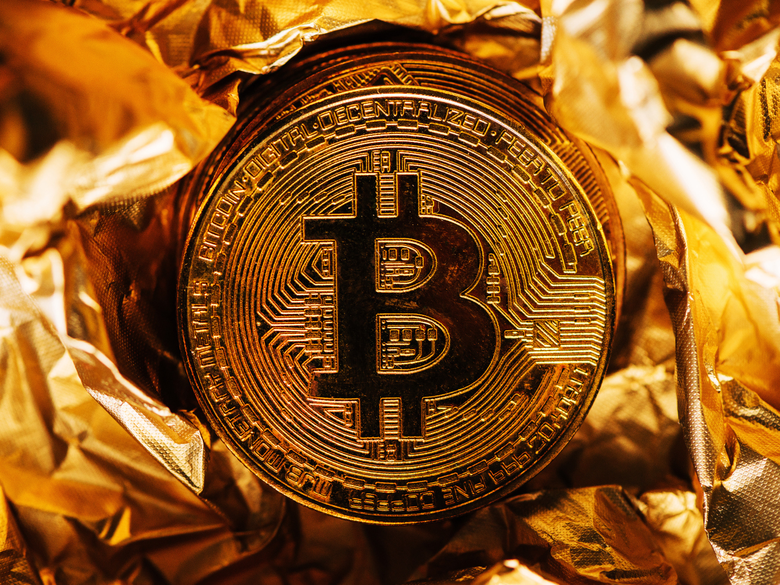 Золотая монета биткоин на фольге