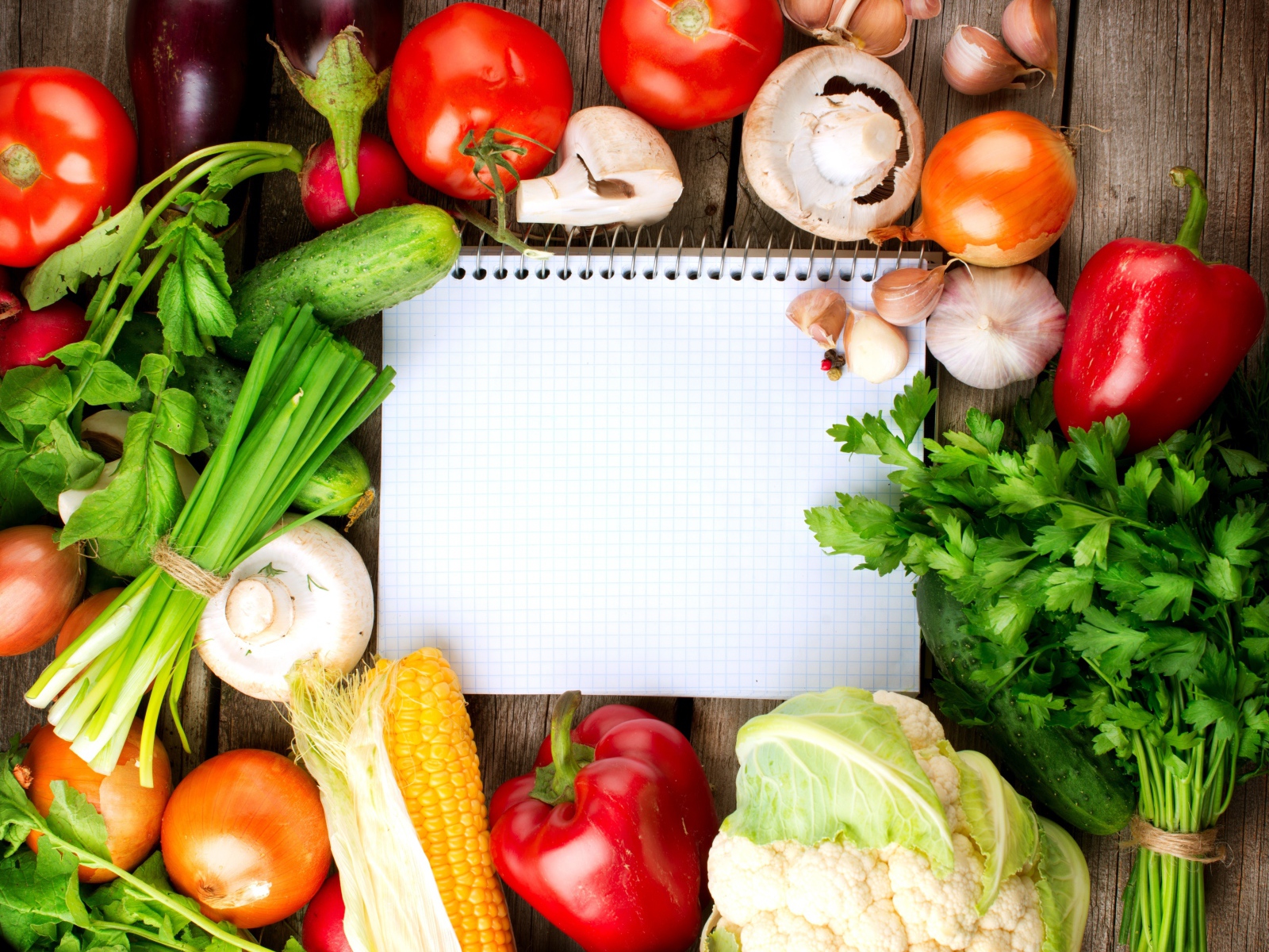 Блокнот со свежими овощами на столе 