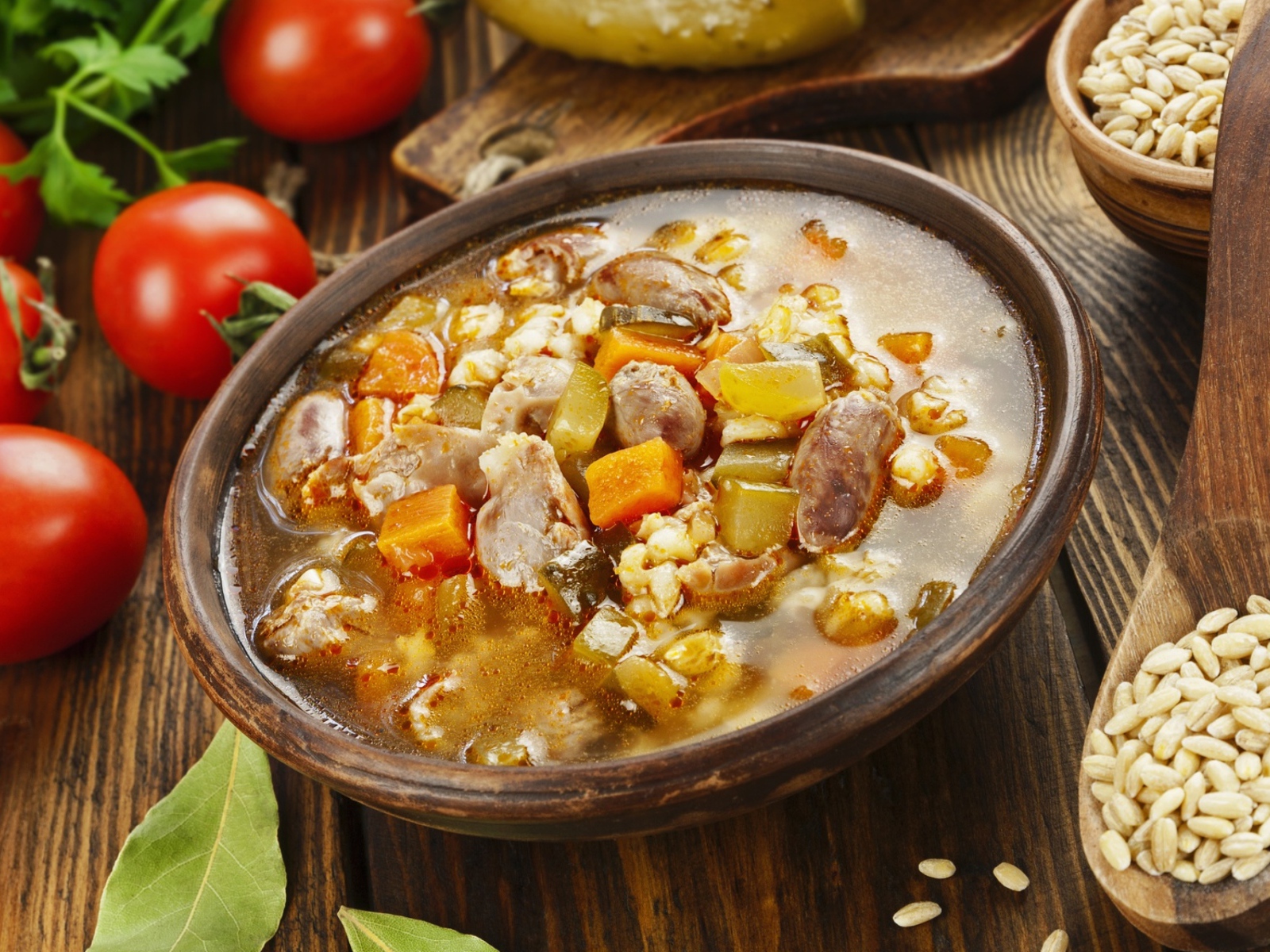 Перловый суп с сердечками на столе с помидорами 