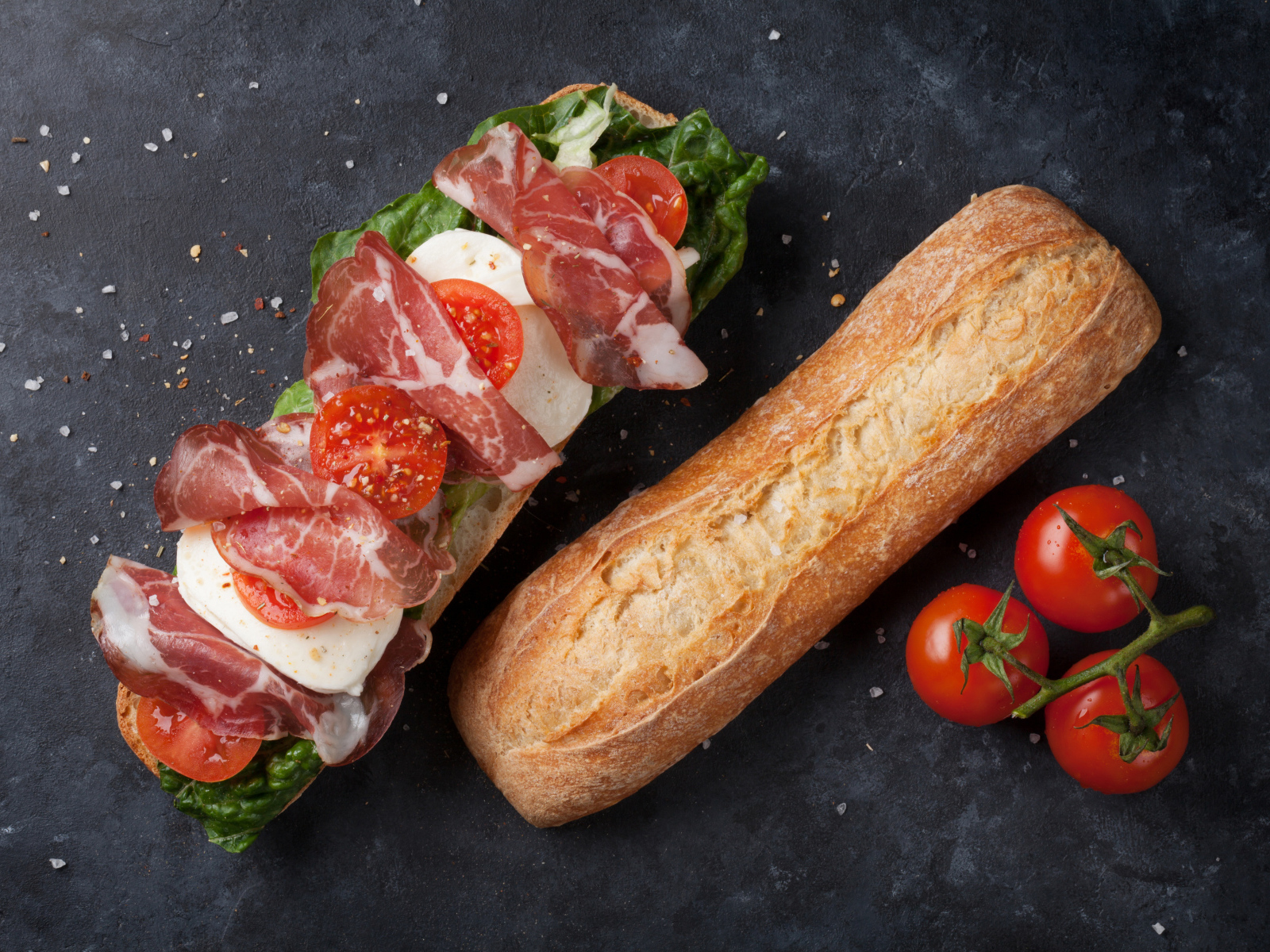 Бутерброд с ветчиной, помидорами, яйцом и листьями салата