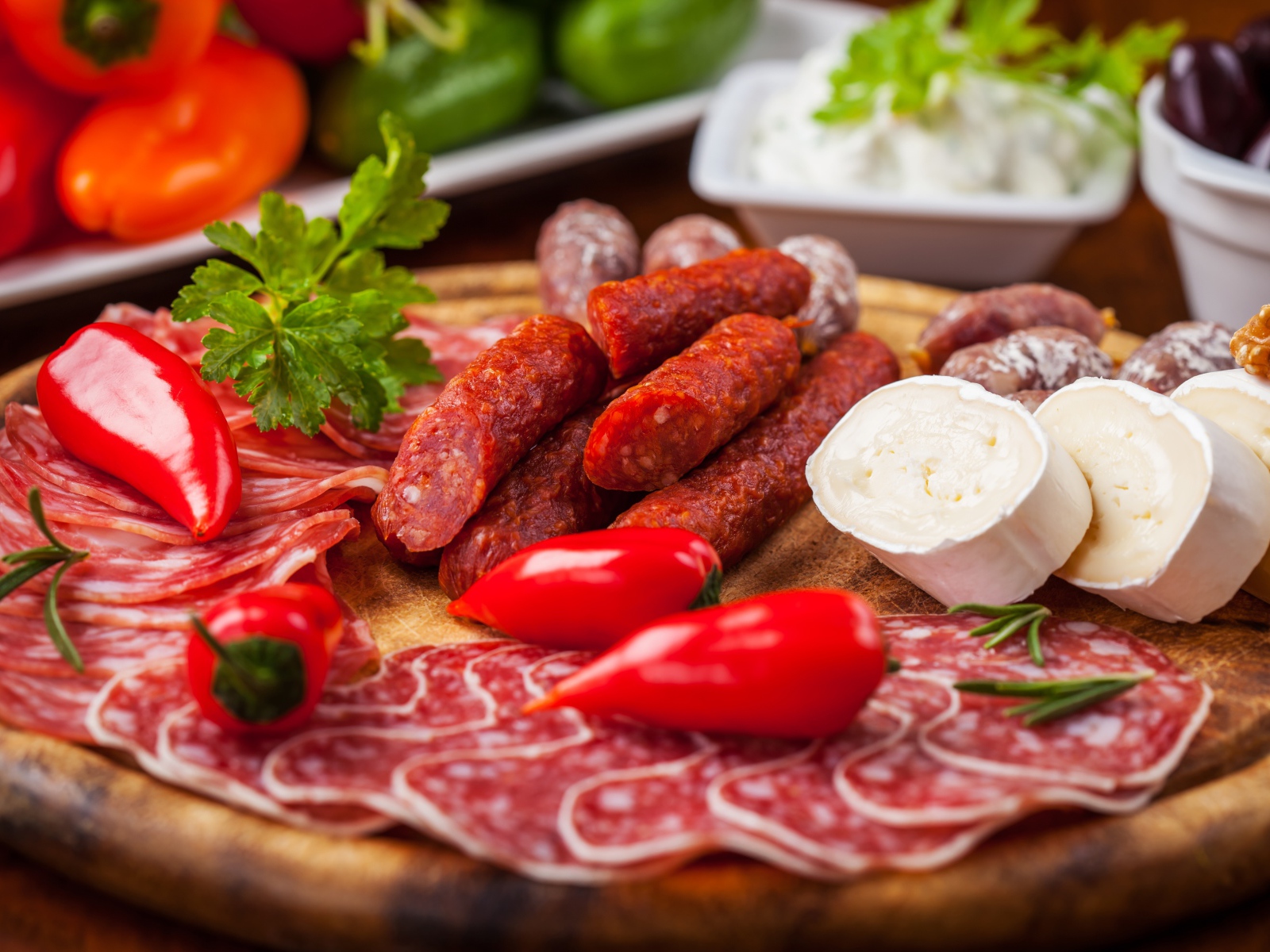 Колбаса с кусками сыра и мяса на столе с перцем