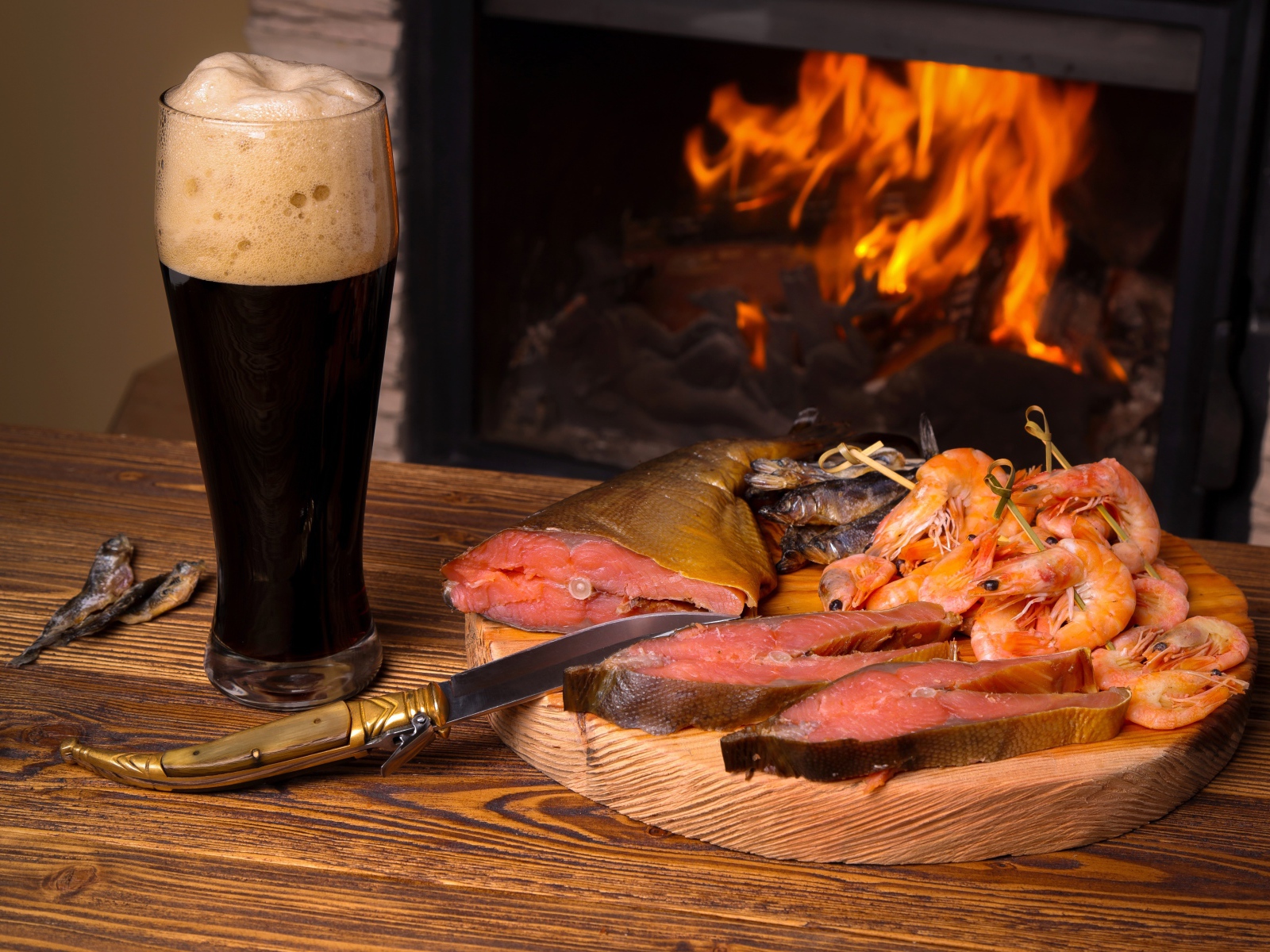 Копченая рыба с креветками у камина с бокалом темного пива