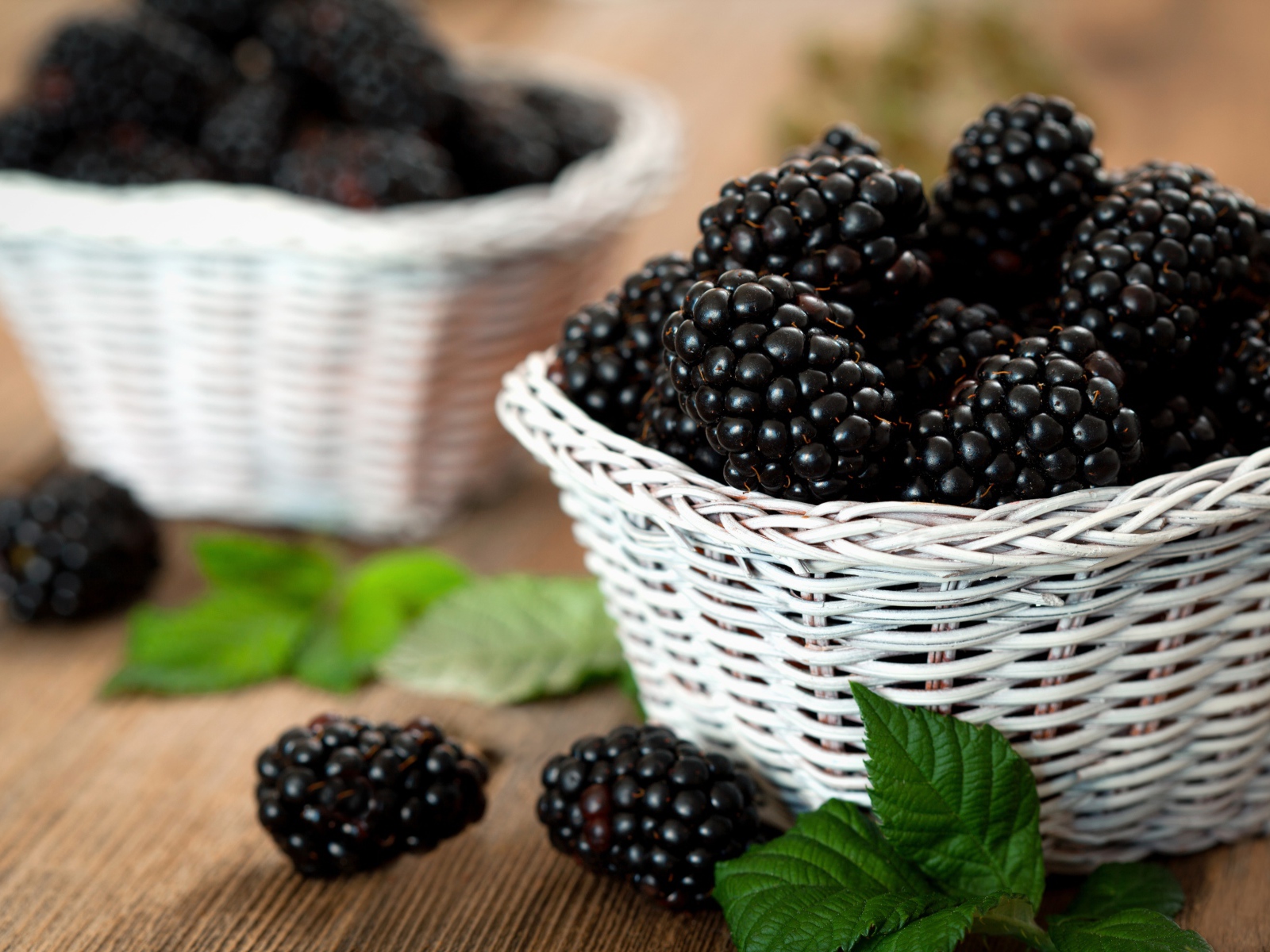 Свежые ягоды ежевики в белой корзинке на столе