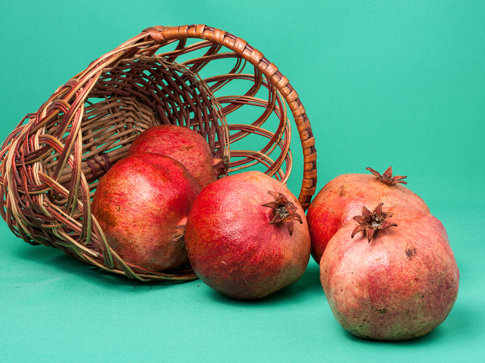 Плоды граната в корзине на голубом фоне