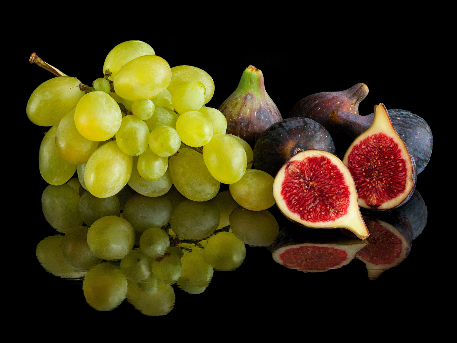 Белый виноград и инжир на черном фоне