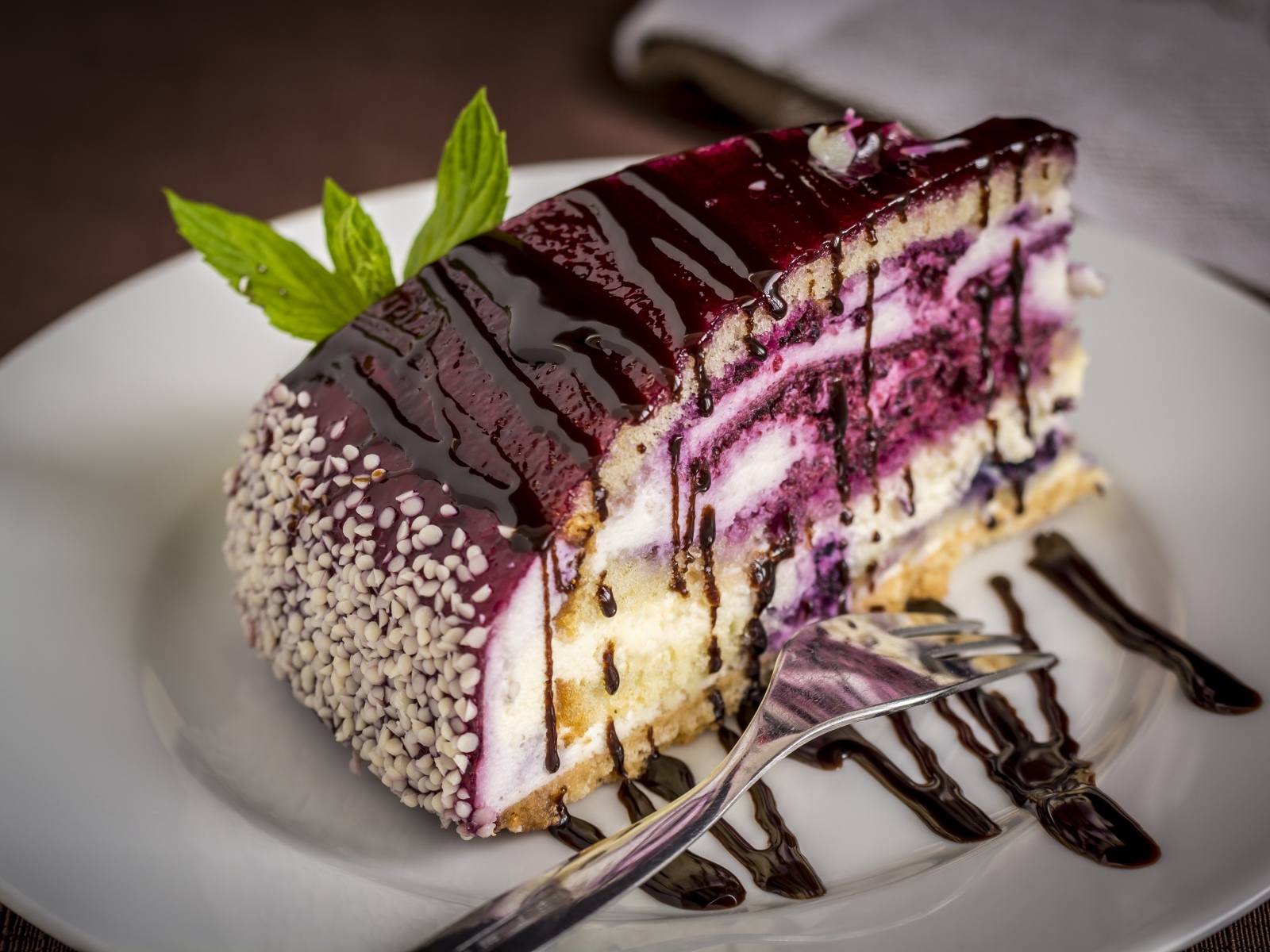 Кусок черничного пирога с джемом на белой тарелке с вилкой