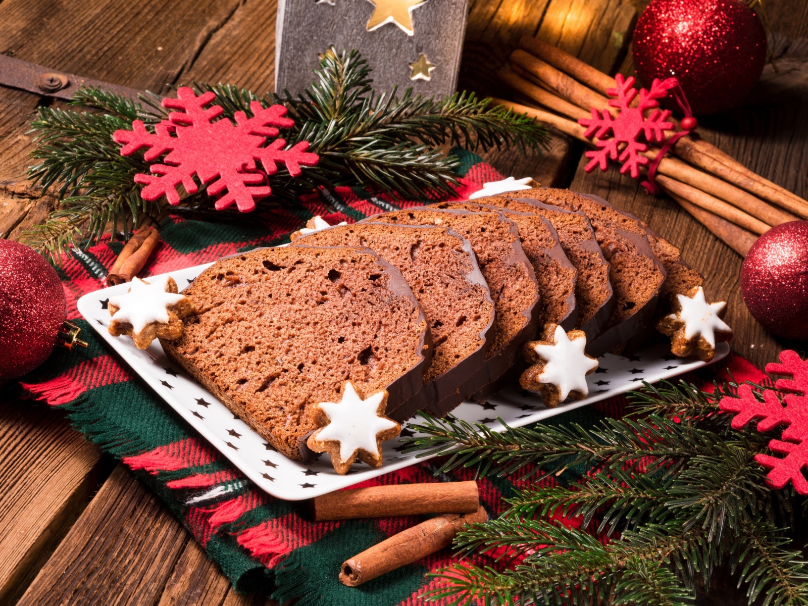 Рождественский кекс на столе с еловыми ветками и корицей