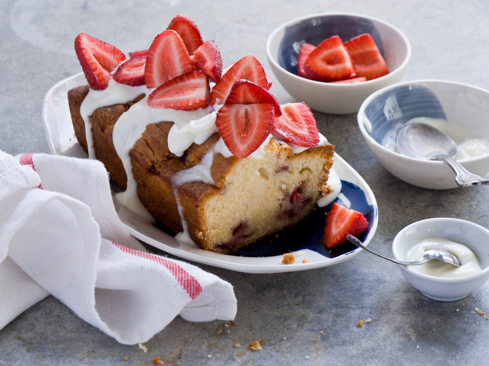 Кекс с кремом на тарелке со свежей клубникой 