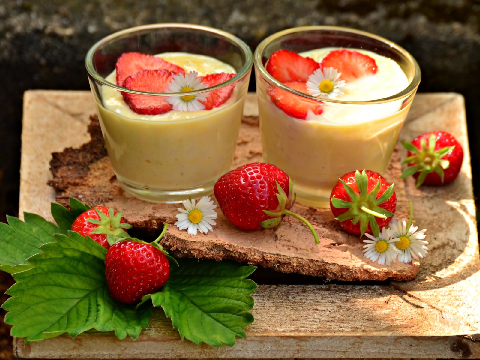 Десерт с йогуртом и свежей клубникой в стаканах на столе