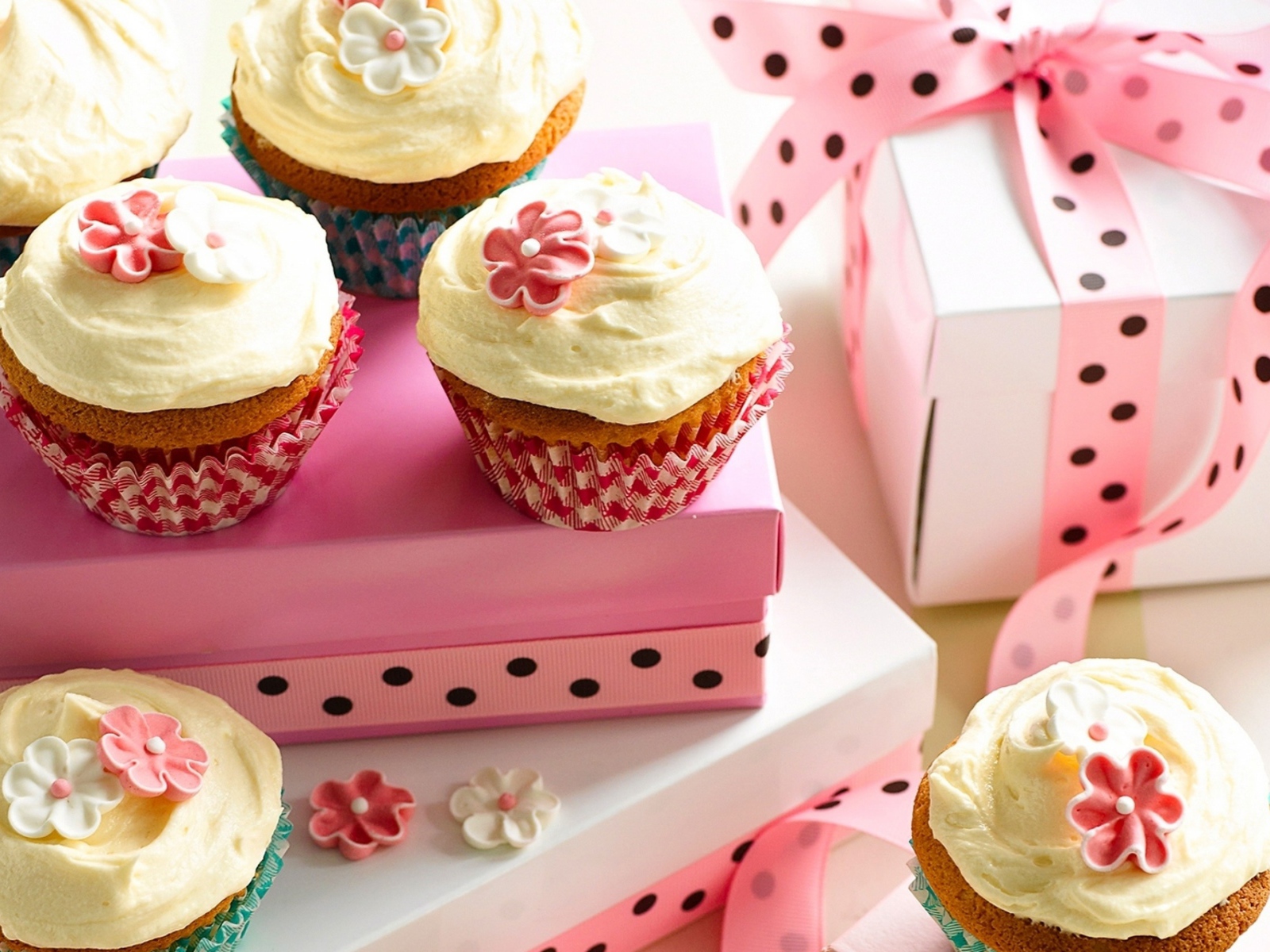 Праздничные кексы с кремом и подарочной коробкой на столе