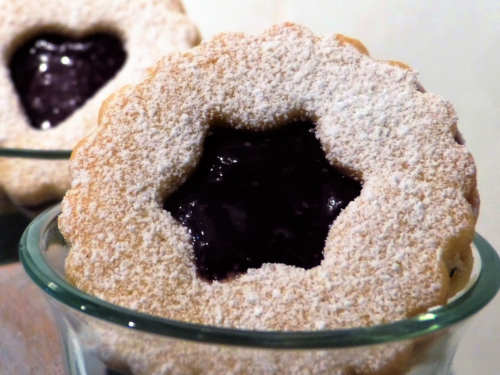 Фигурные печенья с джемом посыпанные сахарной пудрой 