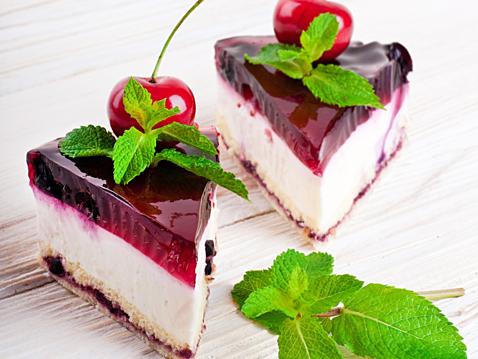 Два аппетитных пирожных с черешней и свежей мятой