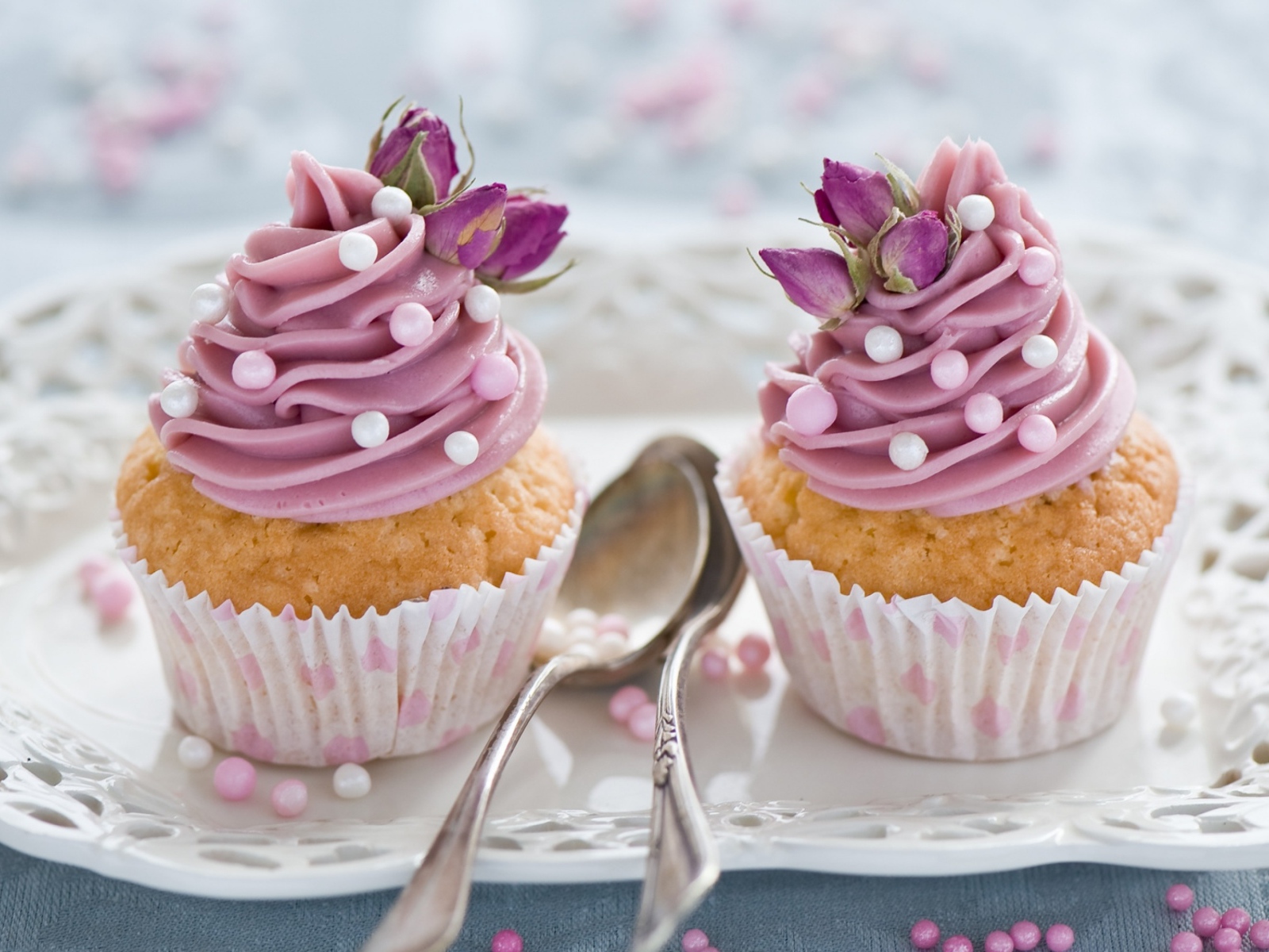 Два вкусных капкейка с кремом на тарелке