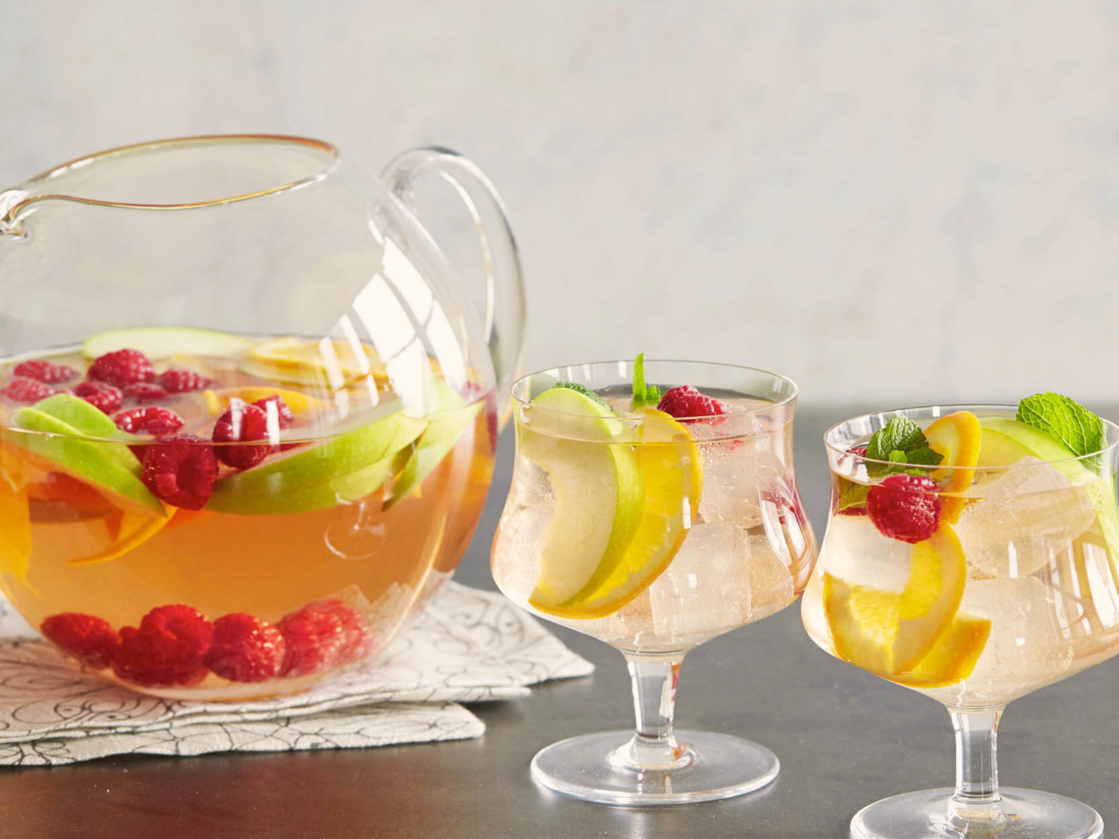 Лимонад в графине на столе с бокалами 