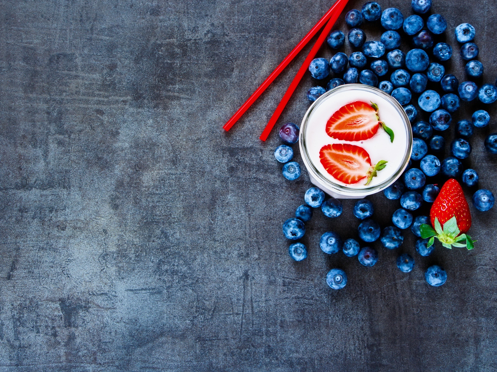 Молочный коктейль с клубникой и черникой на столе 