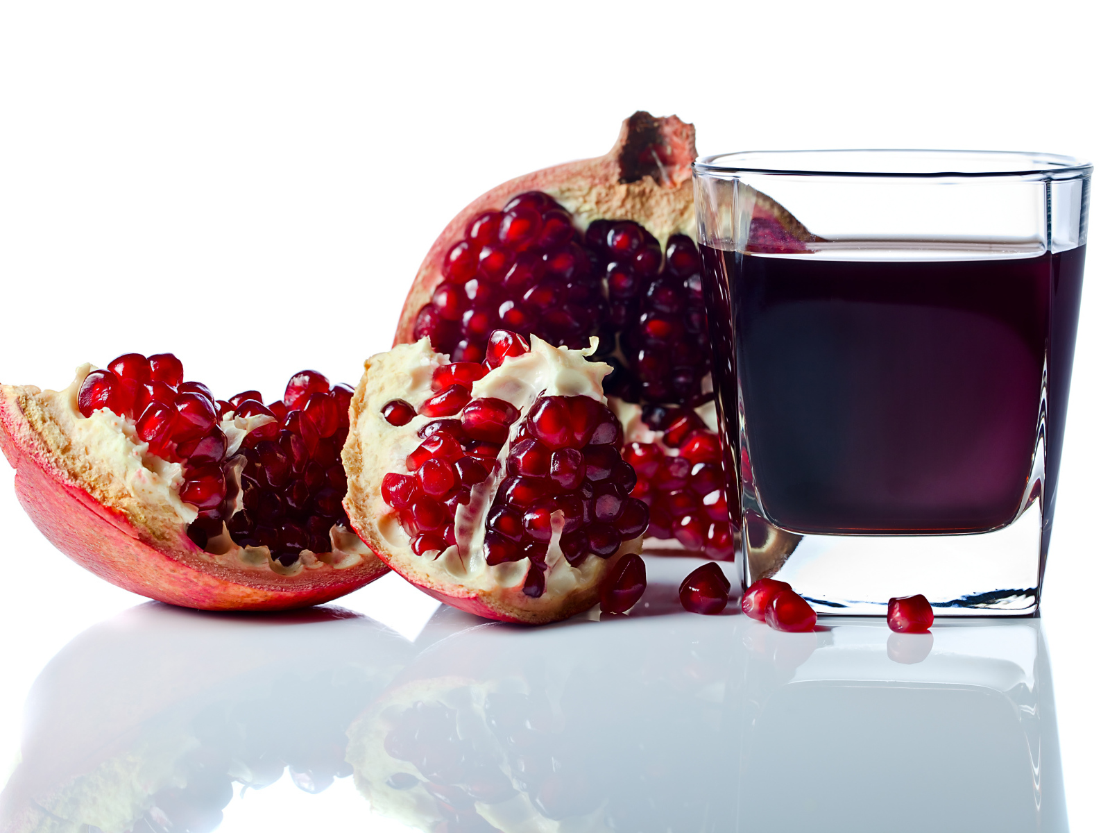 Гранатовый сок с плодом граната на белом фоне