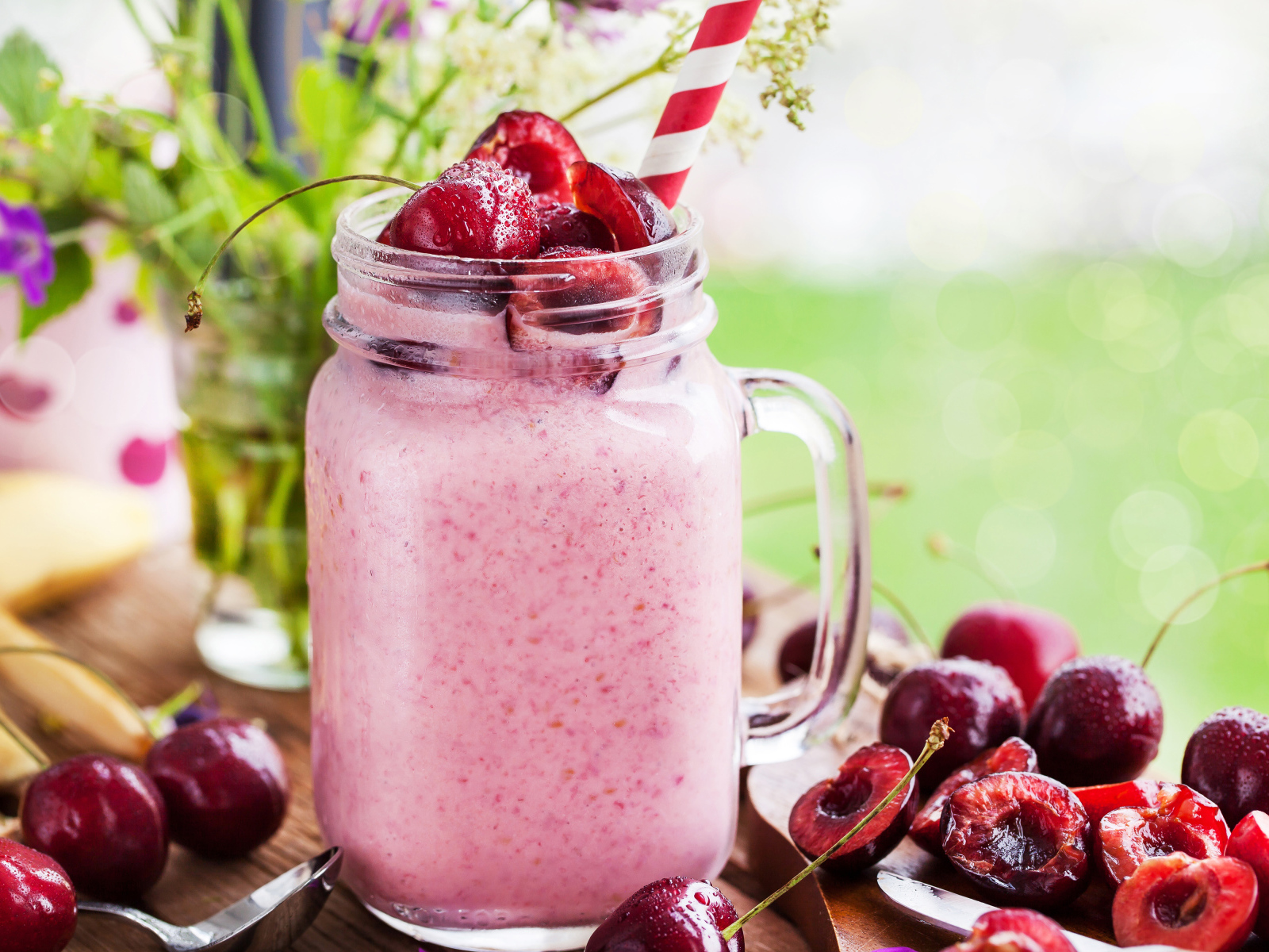 Смузи в бутылке с трубочкой и ягодами черешни 