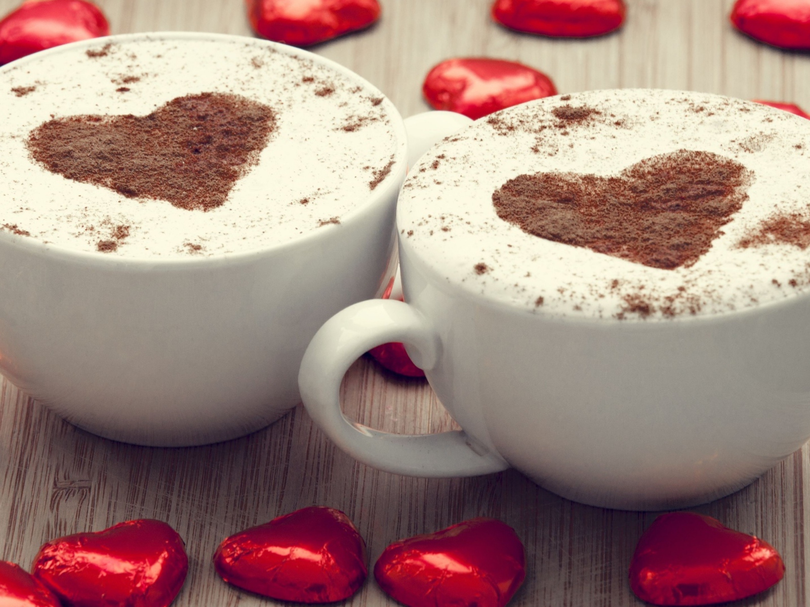 Две чашки кофе на столе с шоколадными конфетами в форме сердца