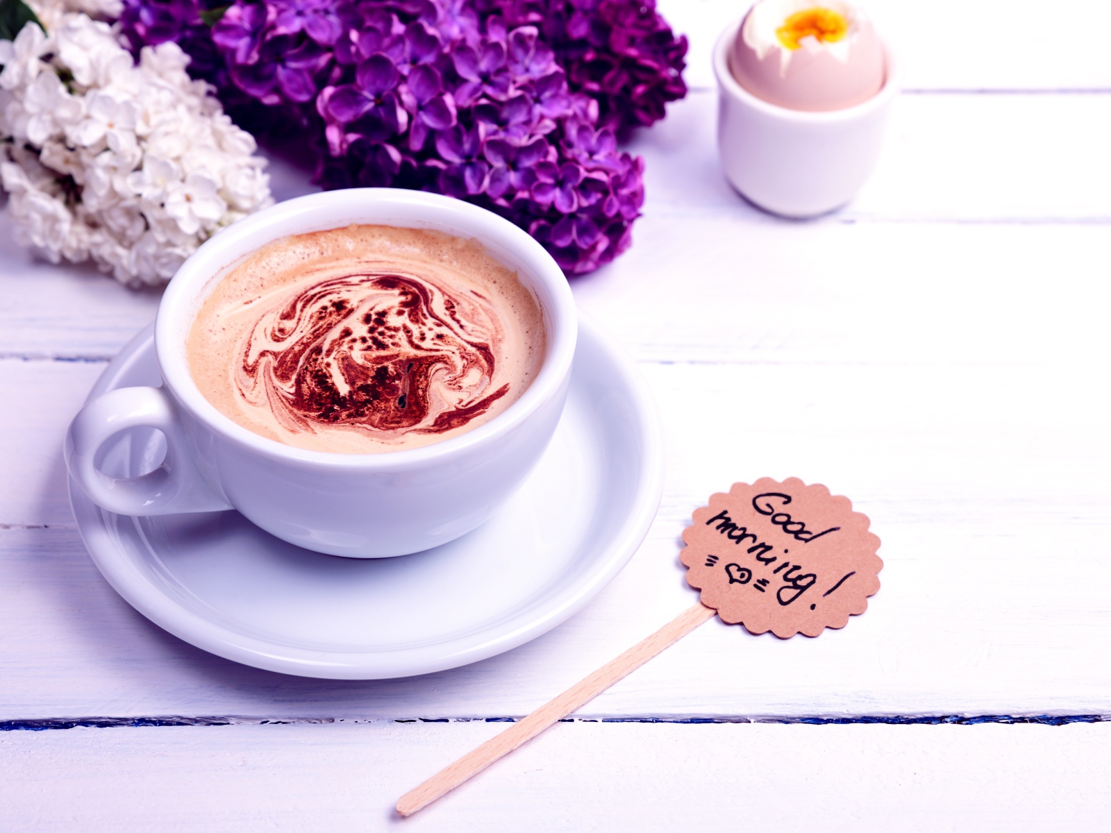 Белая чашка кофе с цветами сирени и яйцом на завтрак