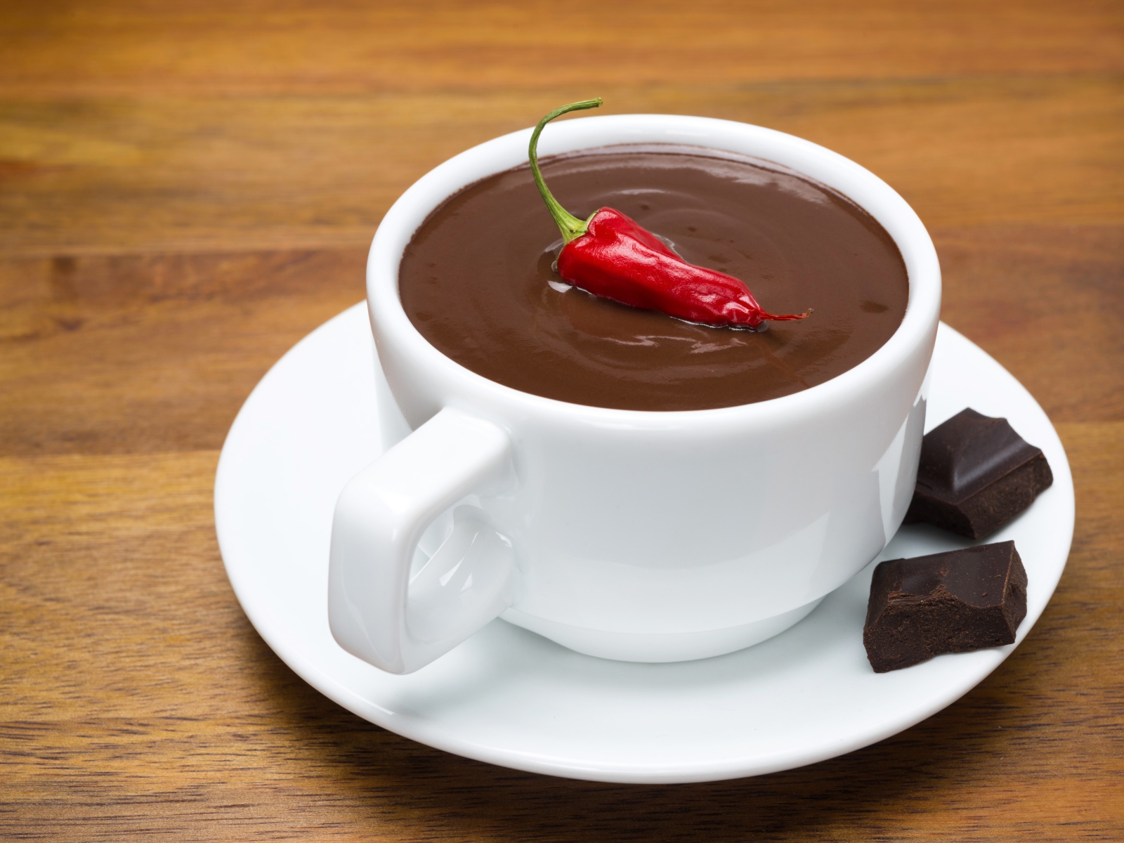 Белая чашка горячего шоколада с красным перцем