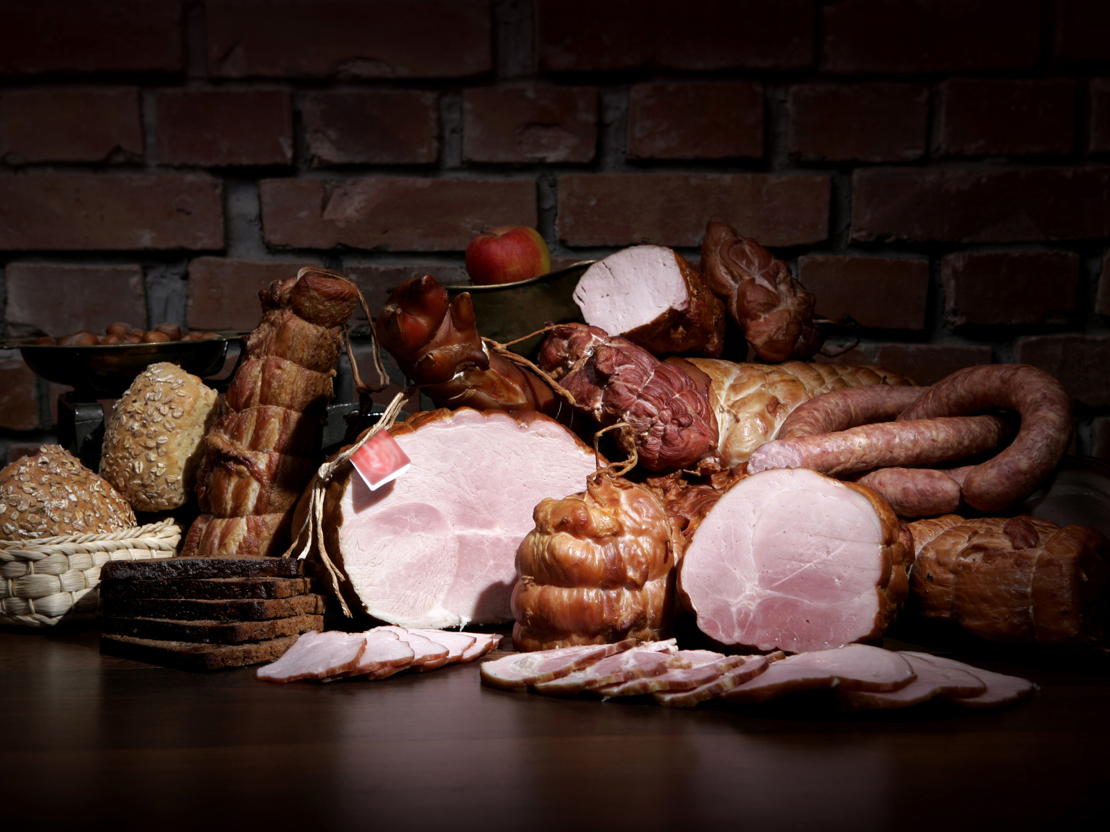 Аппетитные мясные продукты на фоне кирпичной стены 