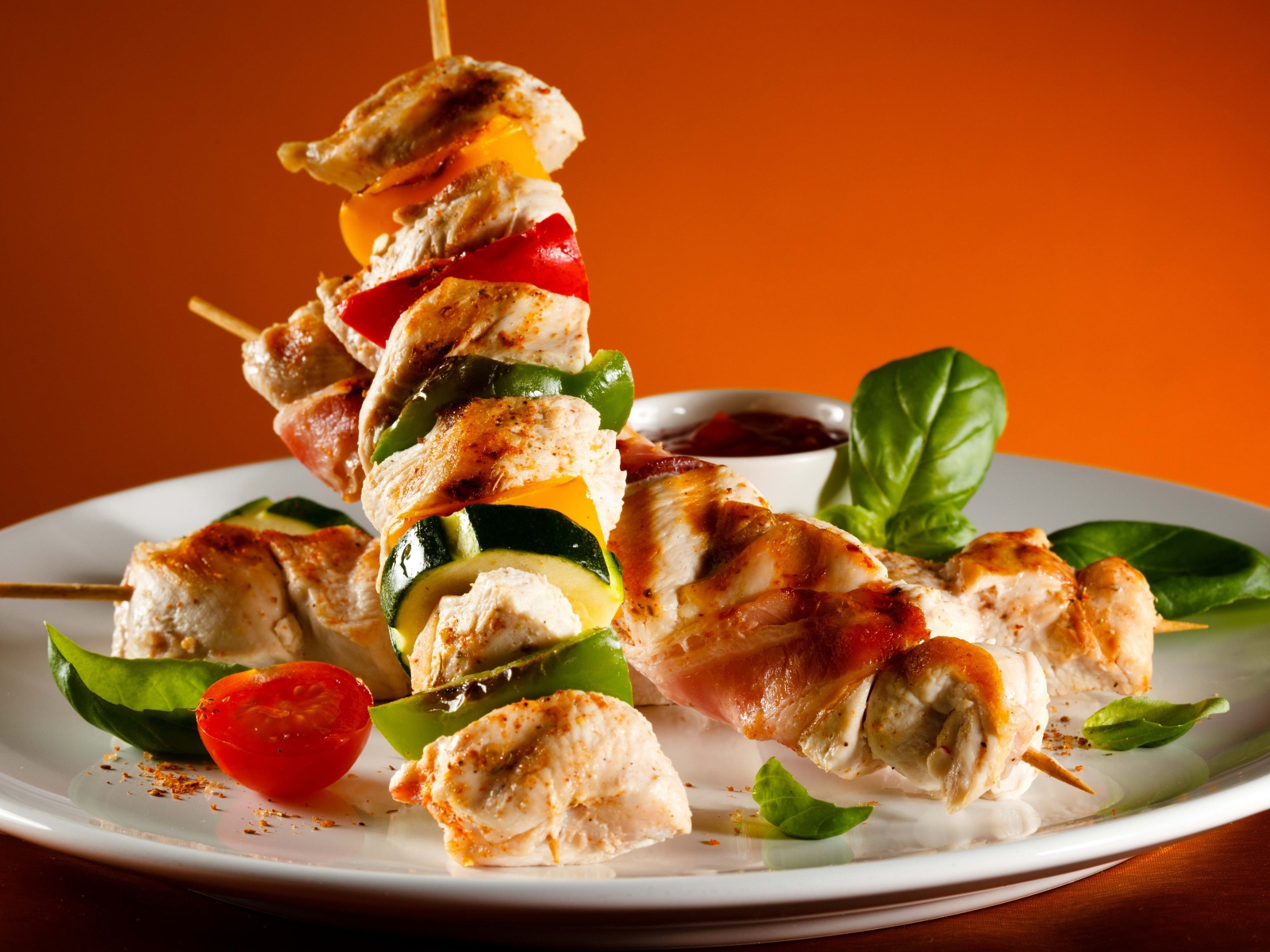 Куриные шашлыки с овощами на белой тарелке