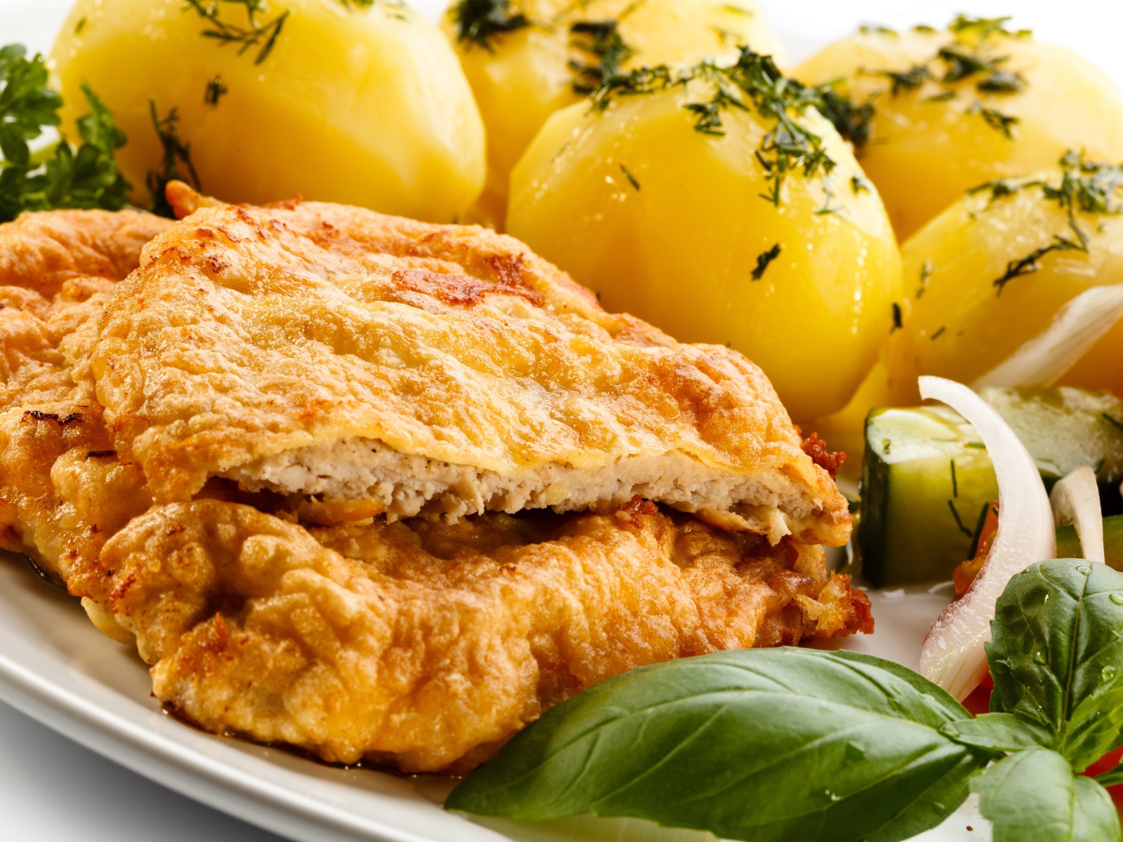 Отбивная на тарелке с вареным картофелем и салатом