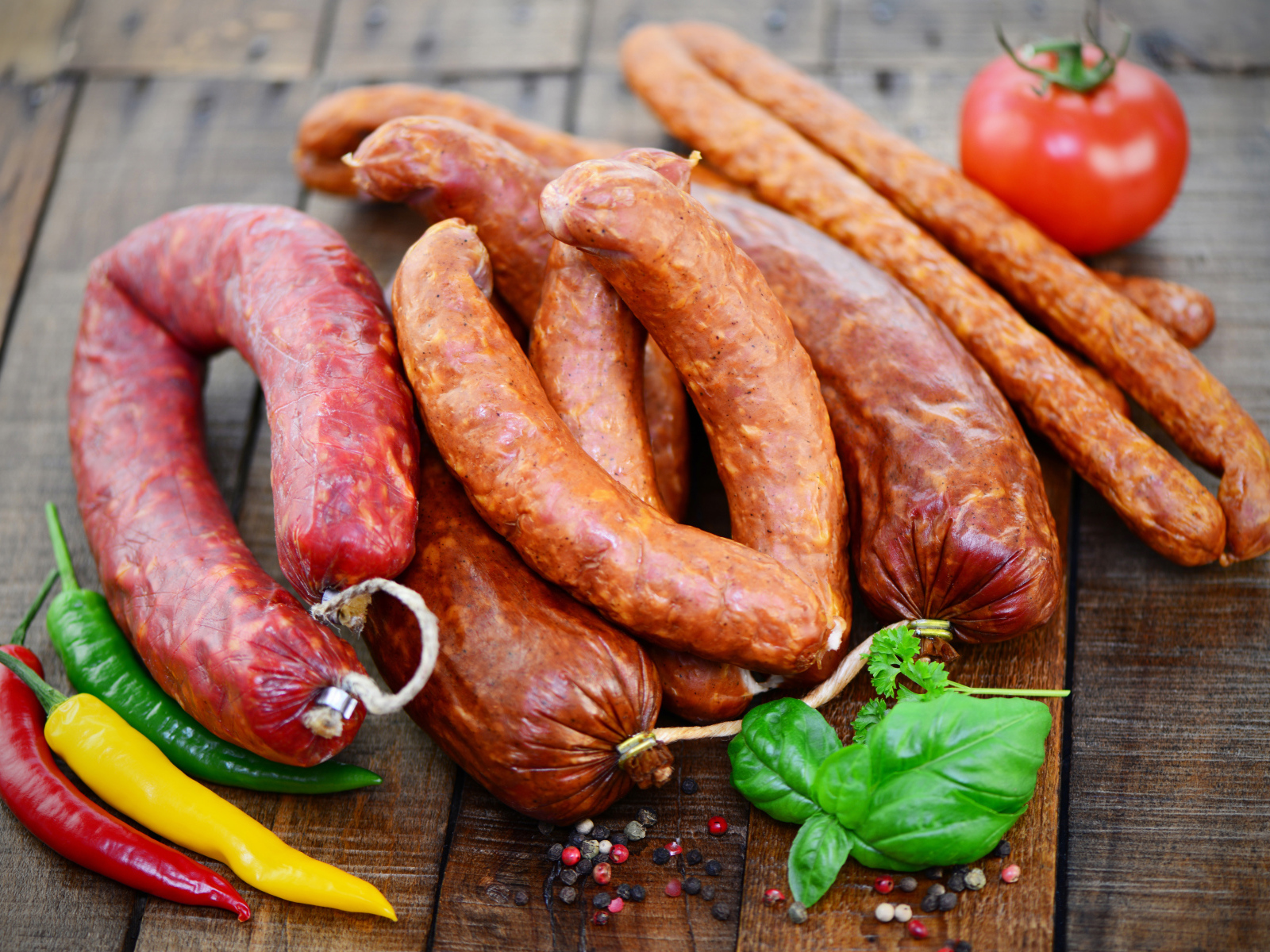 Свежие колбасы с перцем на столе