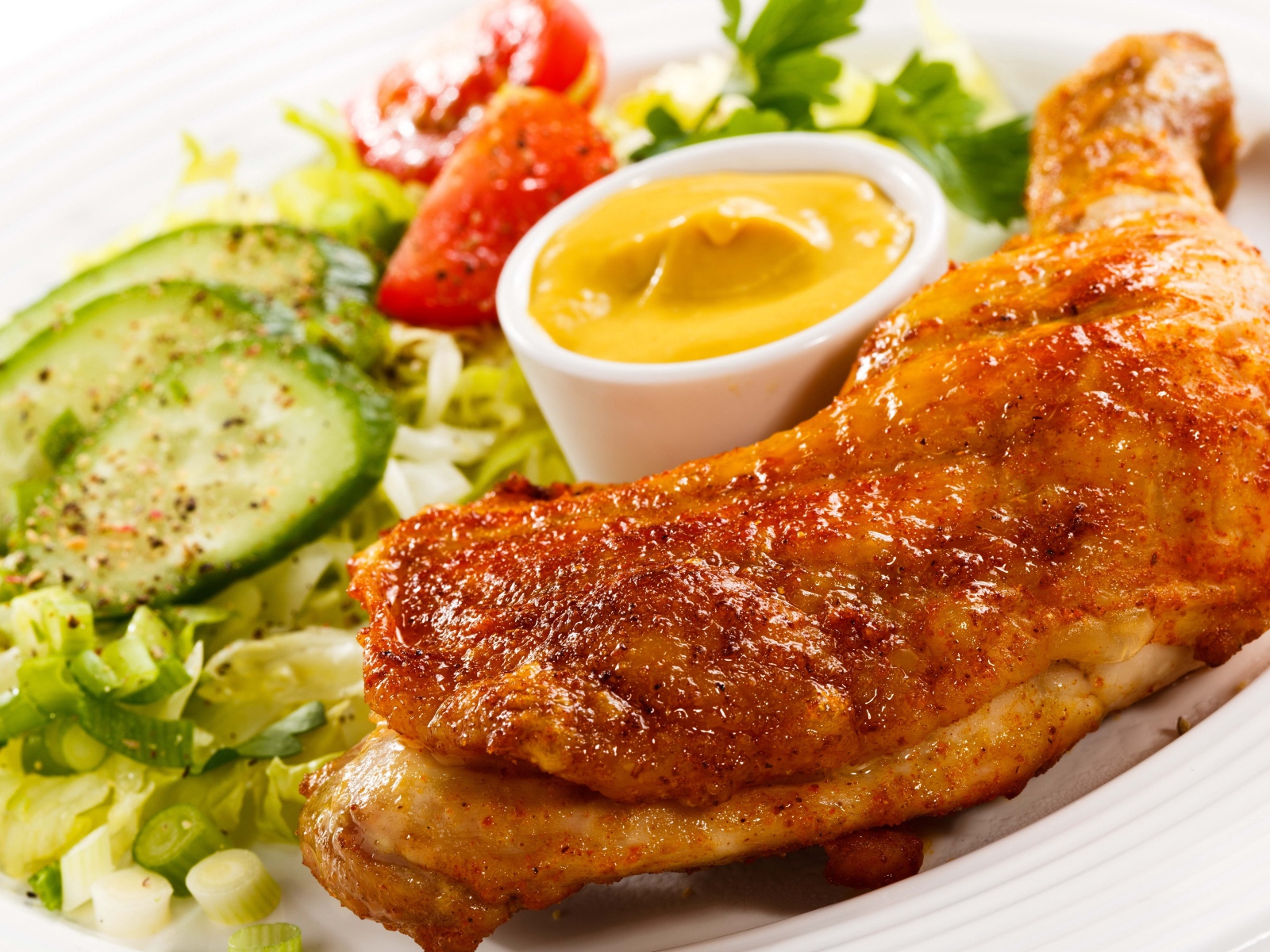 Жареная куриная ножка с овощами и соусом на тарелке