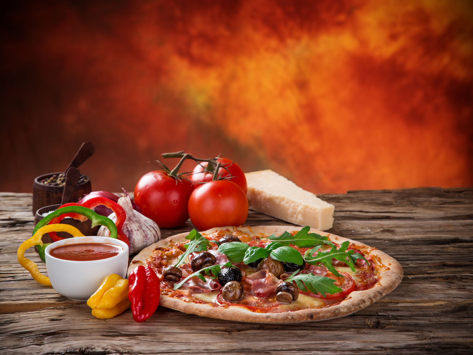 Пицца с колбасой и грибами на столе с соусом и овощами 