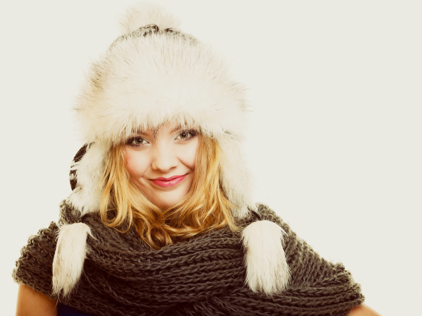 Красивая блондинка в теплой шапке с шарфом на шее
