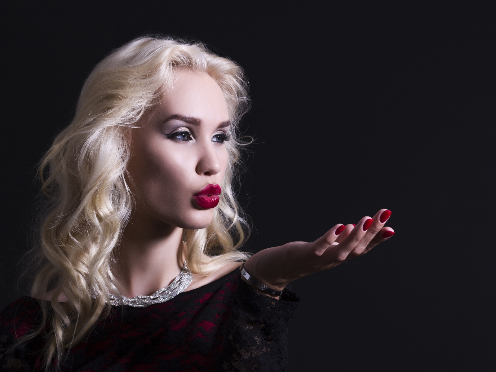 Красивая голубоглазая блондинка с красными губами в черном платье