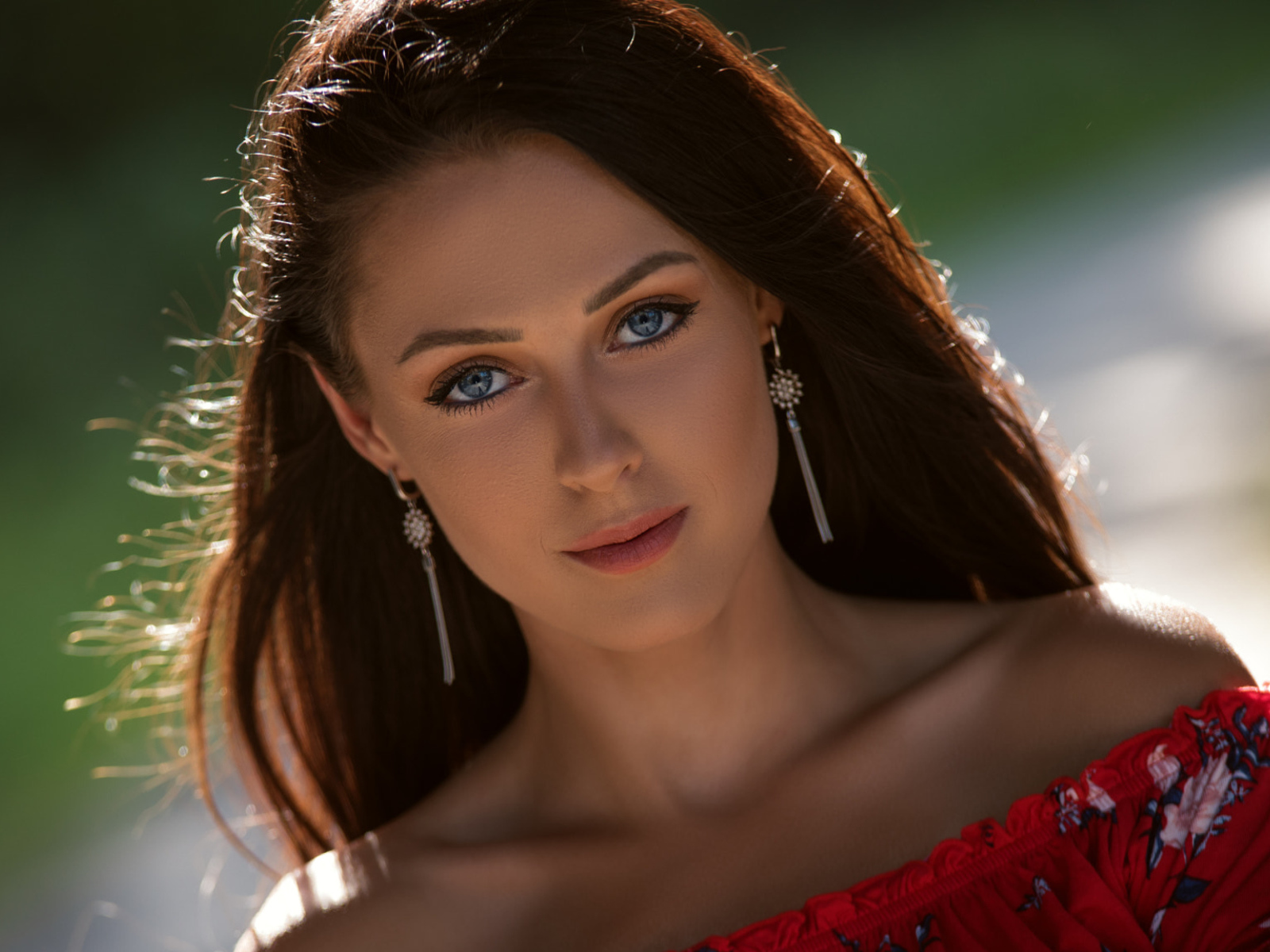 Красивая голубоглазая брюнетка с серьгами у ушах