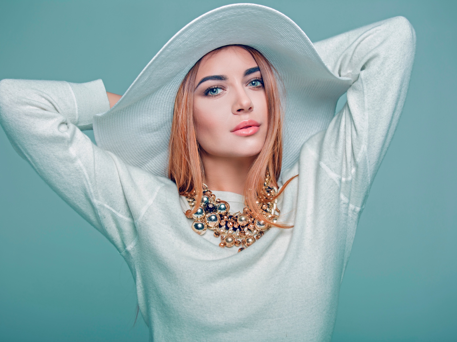 Красивая голубоглазая девушка в большой белой шляпе