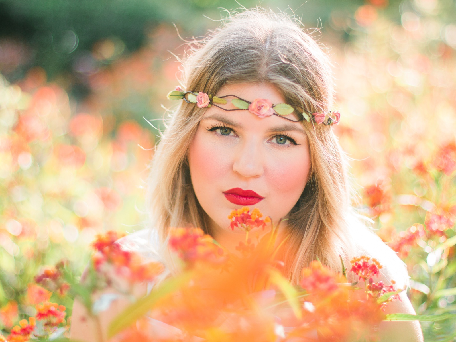 Красивая голубоглазая девушка в красных цветах