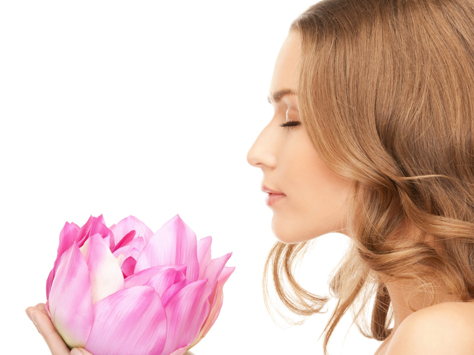 Красивая девушка шатенка наслаждается ароматом лотоса 