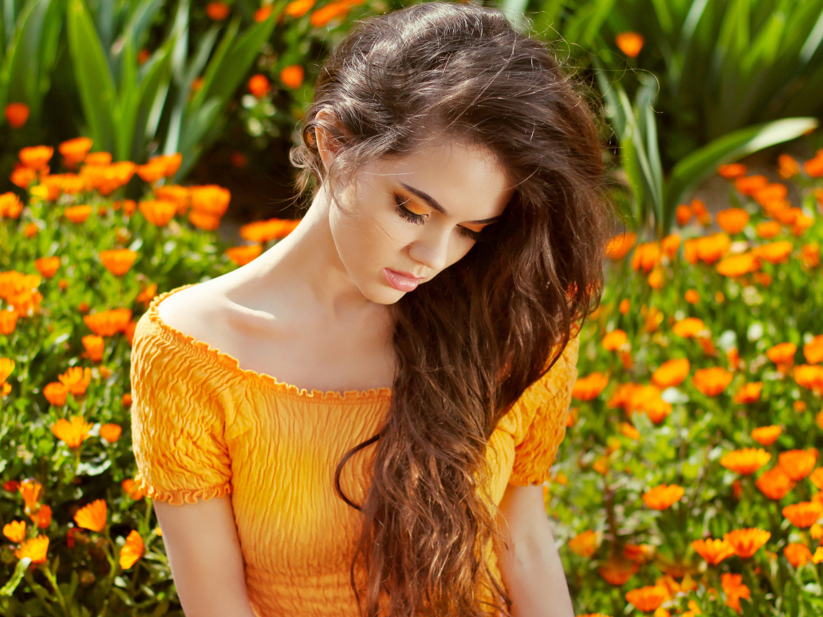 Красивая девушка у цветов календулы